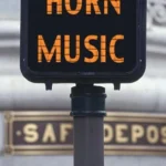A walk/don't walk sign modified to display 'Horn Music,' serving as the cover image for French Horn Sheet Music Archive, Vol. 2.
